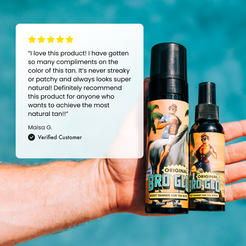 Hand holding two spray tan bottles with vintage pin-up artwork against turquoise background, beside five-star customer review.