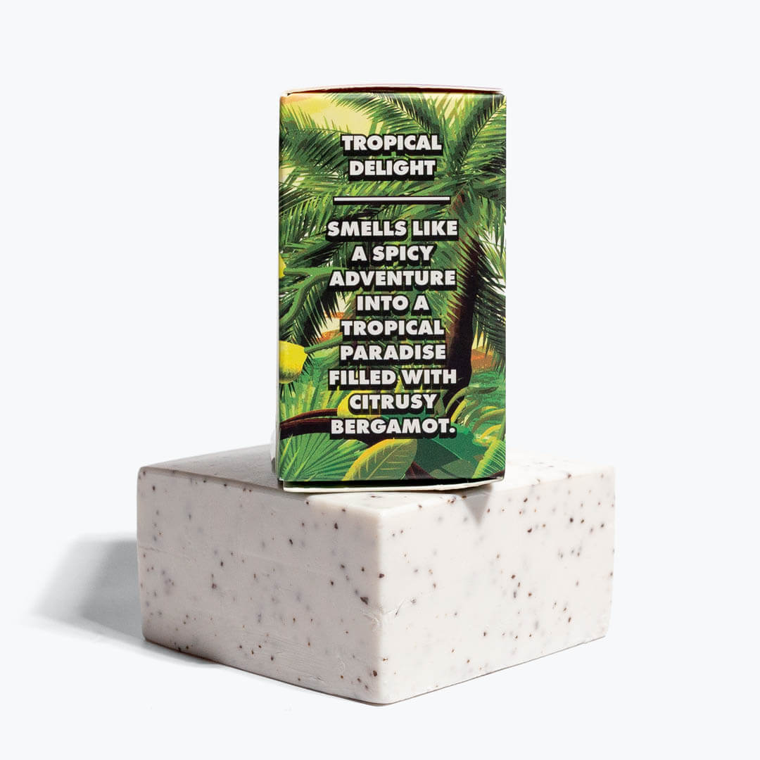 Tropical-patterned soap box displayed on a speckled white exfoliating bar of soap.