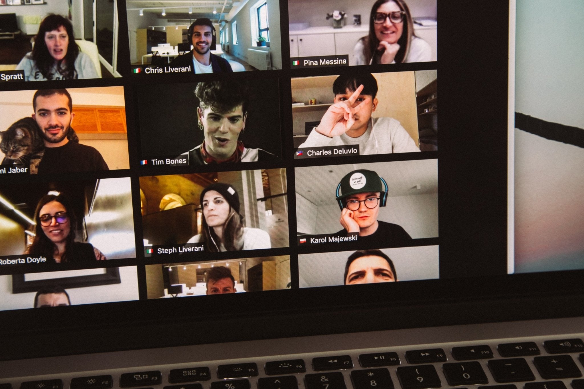 Multiple people on a video call grid, some with improved tan appearance, demonstrating Zoom meeting presence.