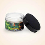 An open jar of white moisturizing cream with a black lid resting beside it against a beige background.